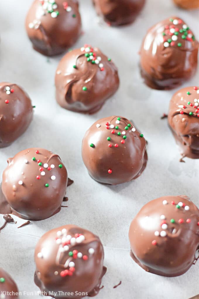 Nutter Butter Truffles on parchment paper with Christmas sprinkles.