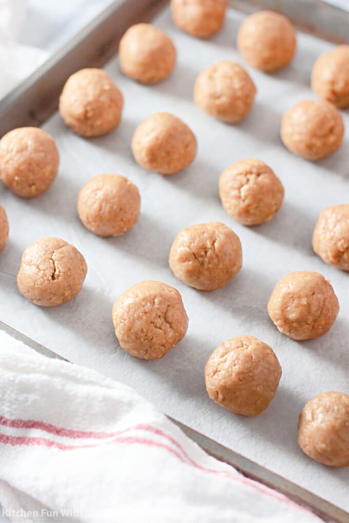 Nutter Butter dough rolled into balls and arranged on a cookie sheet.