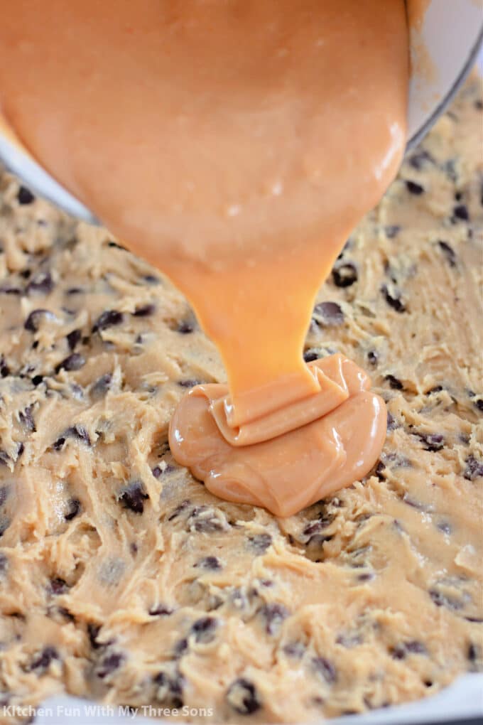 pouring caramel sauce over chocolate chip cookie dough.