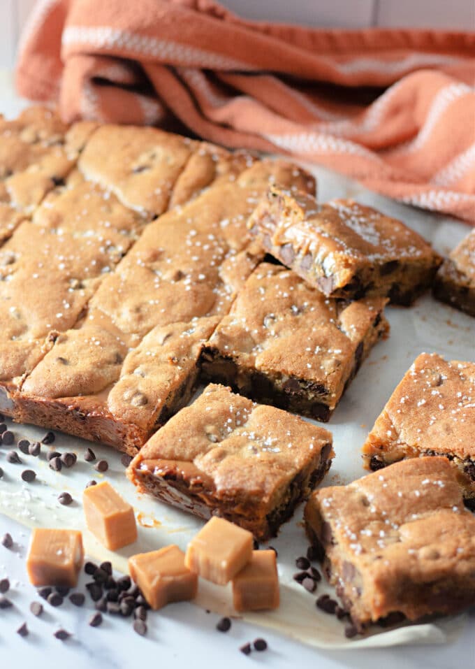 sliced Salted Caramel Chocolate Chip Cookie Bars with an orange napkin.