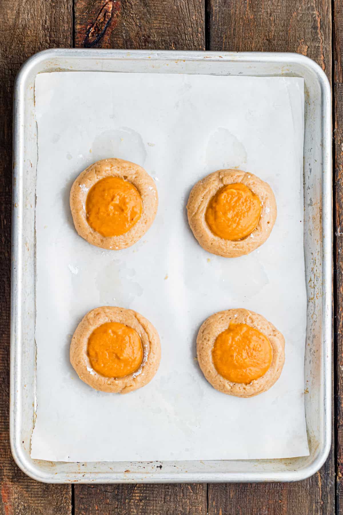 These Pumpkin Pie Cookies combine a soft, buttery cinnamon cookie with a creamy pumpkin pie filling baked right into the center. filling the cookie dough with pumpkin puree
