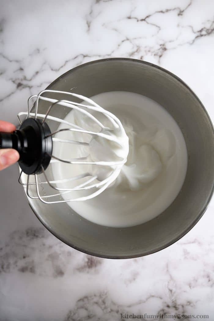 Beating the cream ingredients in a mixing bowl.