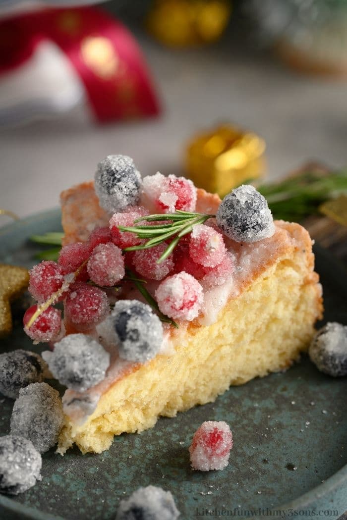 A slice of the cake topped with sugared-berries.