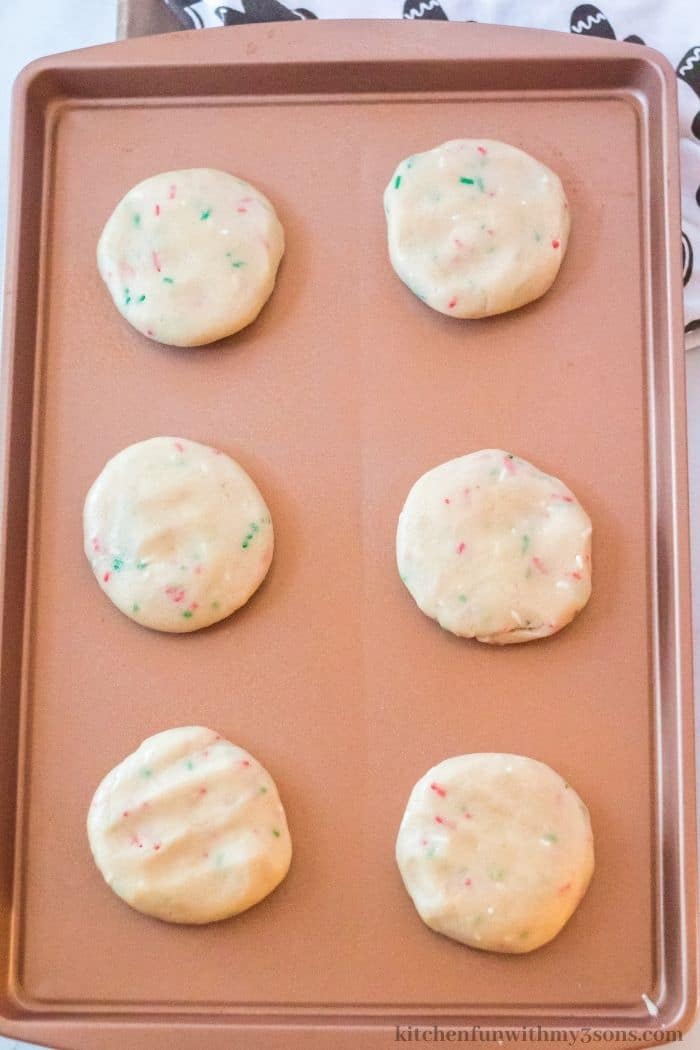 The flattened cookies on a sheet pan.