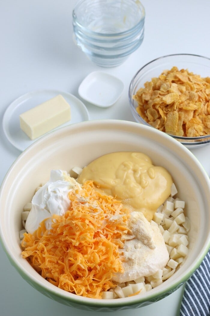 diced potatoes, cheese, sour cream, seasonings and cream of chicken soup in a bowl