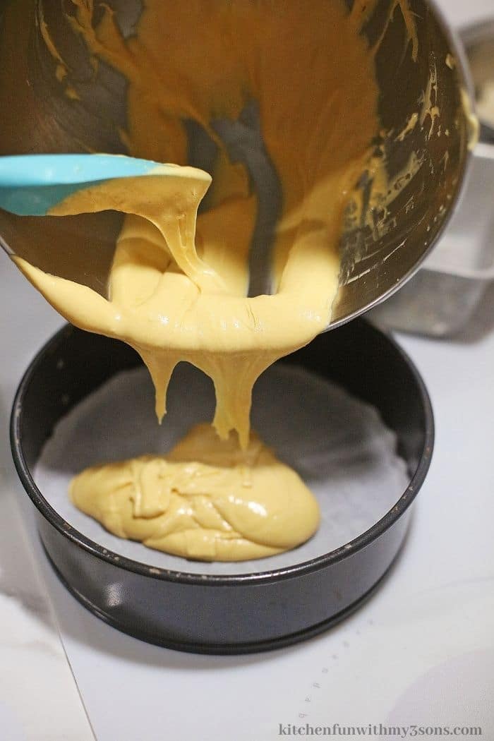 Adding the cheesecake batter into the pan.