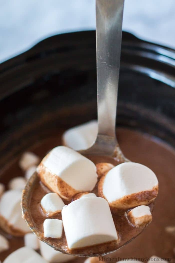 A spoon lifting up some of the peanut butter hot chocolate.