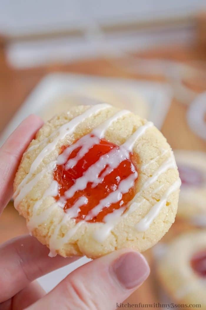A hand holding a strawberry cookie.