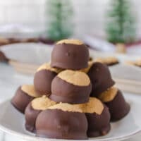 A neat stack of buckeye peanut butter balls presented on a plate.