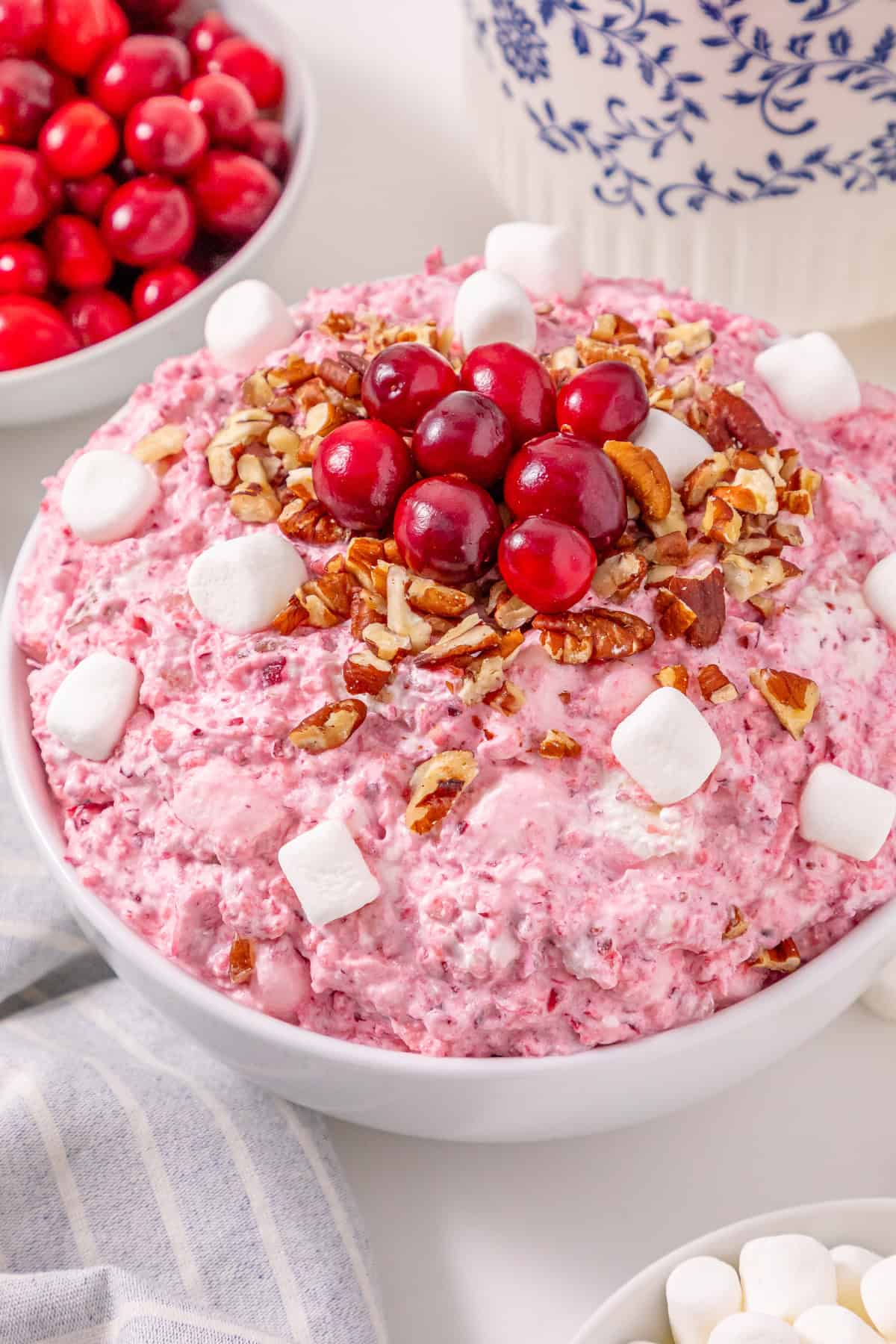 This Cranberry Fluff Salad is a blend of chopped cranberries, crushed pineapple and mini marshmallows tossed in a sweetened whipped cream cheese mixture. Cranberry Fluff Salad in a serving bowl