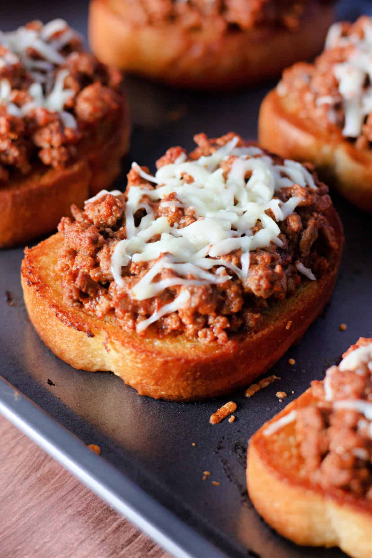 Spice up your weeknight dinner routine with these irresistible Garlic Bread Sloppy Joes! Picture crispy, golden garlic Texas toast piled high with a rich, savory meat sauce and melted mozzarella cheese. This Italian-inspired twist on a classic will have your family asking for seconds! It’s quick, easy, and bursting with flavor, making it the perfect go-to meal for busy nights. Garlic Bread Sloppy Joes on a pan