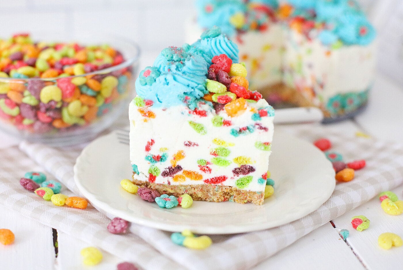 A piece of the Rainbow Trix Cereal Cheesecake on a serving plate.
