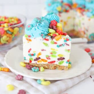 A piece of the Rainbow Trix Cereal Cheesecake on a serving plate.