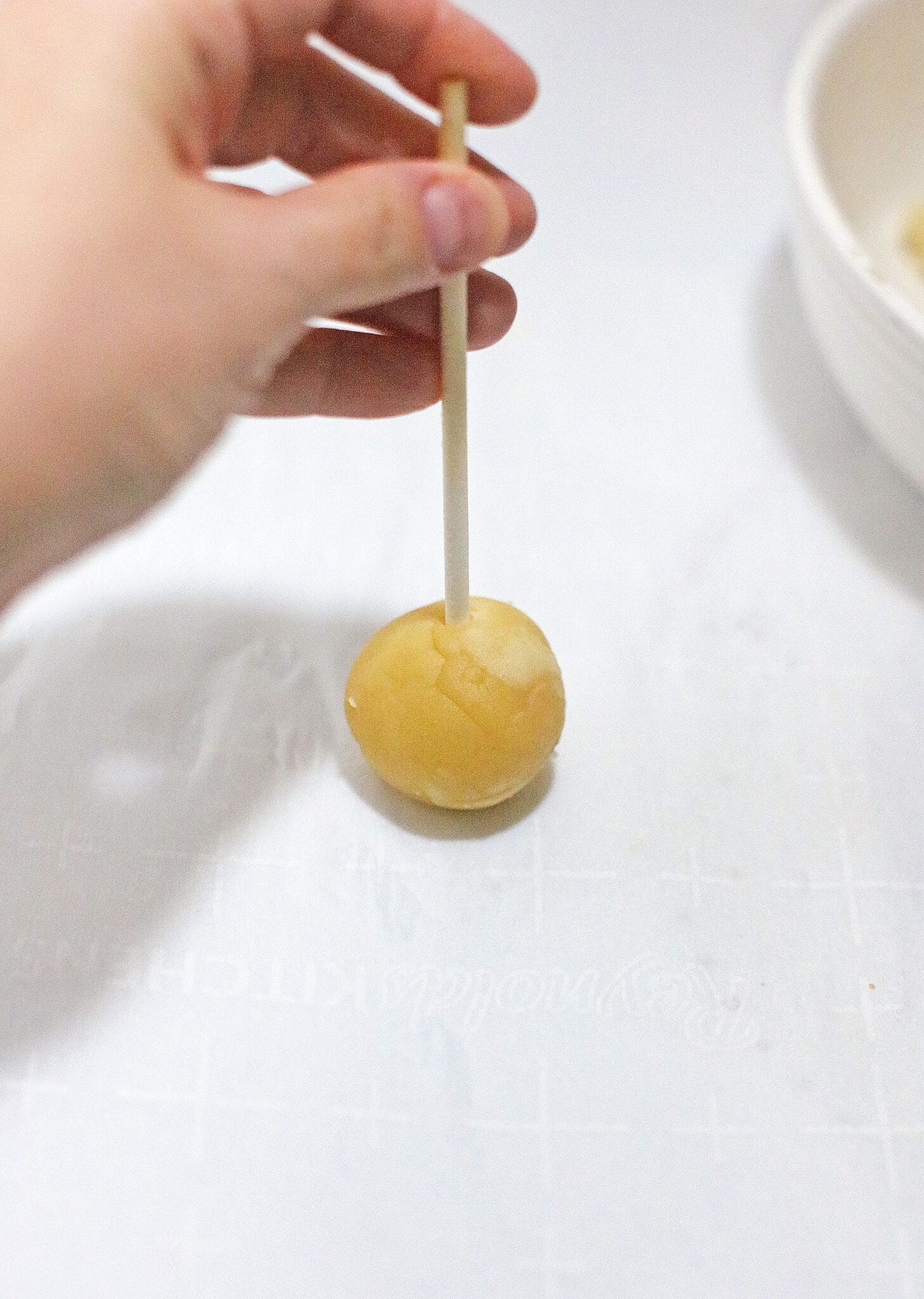 Placing the stick in the cake ball.