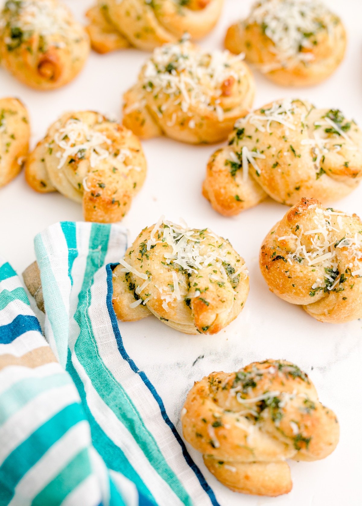 Baked garlic knots topped with garlic and herb butter.