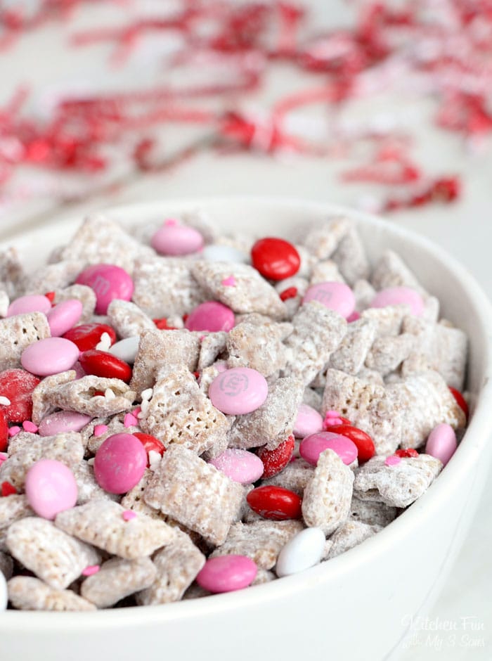 This Valentine Puppy Chow recipe is perfect for Valentine's Day because it's packed with pink and red M&M's and lots of sprinkles.