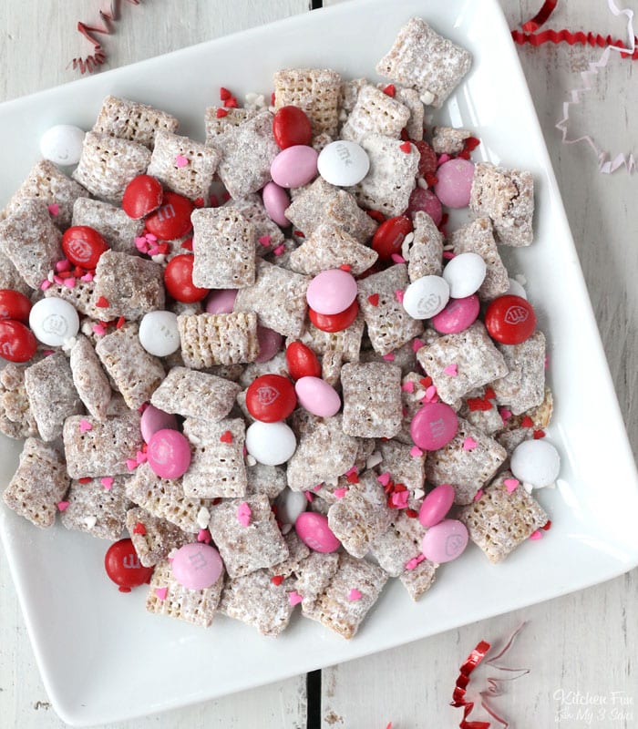 This Valentine Puppy Chow recipe is perfect for Valentine's Day because it's packed with pink and red M&M's and lots of sprinkles.