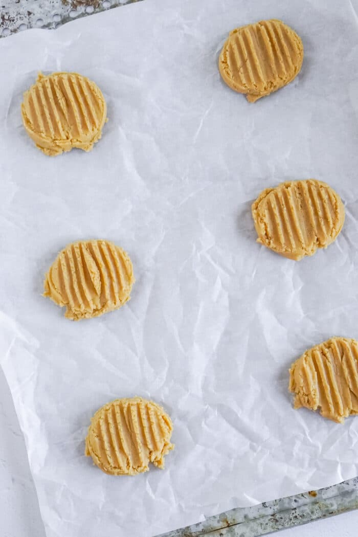 Peanut butter cookies on a parchment-lined baking sheet.