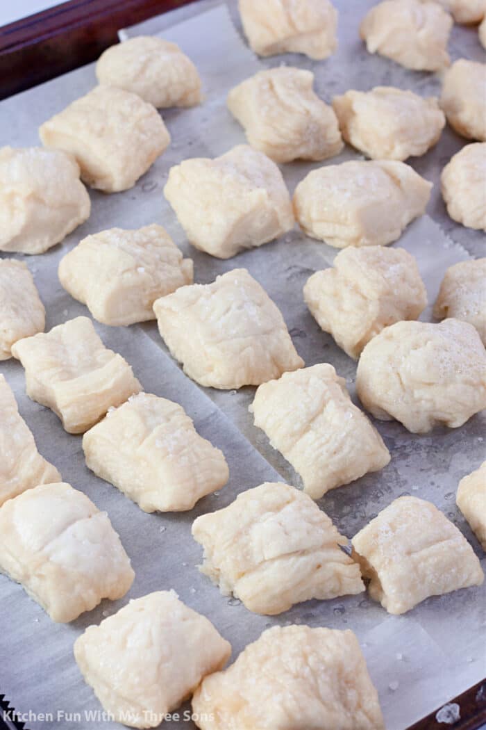 boiled dough with salt on a parchment paper lined baking sheet.