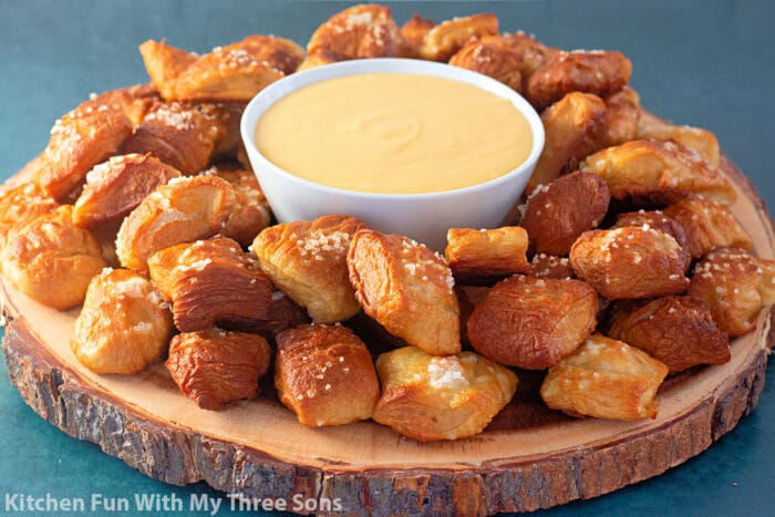 wooden tray of Soft Pretzel Bites with Cheese Sauce.