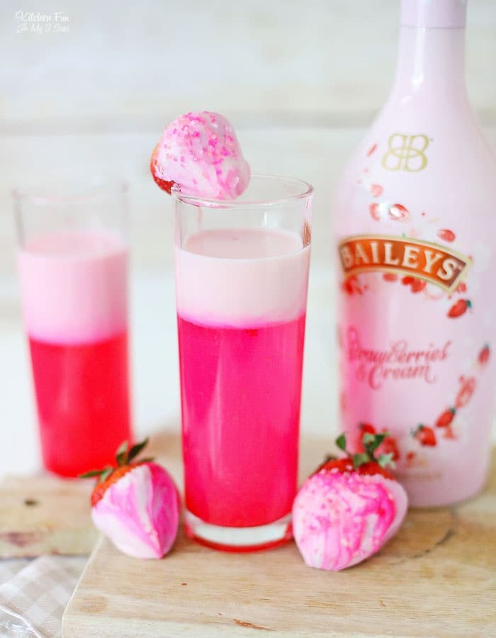 Strawberry Sparkle Cocktail with a strawberry shimmer layer of white chocolate and strawberry syrup and Bailey's strawberries and cream. Perfect drink for Valentine's Day!