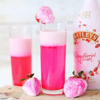 Strawberry Sparkle Cocktail with a strawberry shimmer layer of white chocolate and strawberry syrup and Bailey's strawberries and cream. Perfect drink for Valentine's Day!