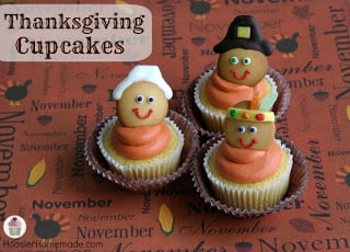 Three vanilla cupcakes with pilgrim and Native American decorations on top