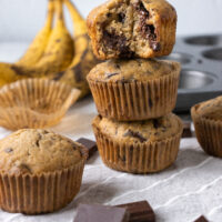 Chocolate Chunk Banana Muffins stacked on top of each other.