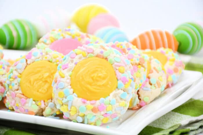 The Easter Thumbprint cookies with easter eggs behind them.