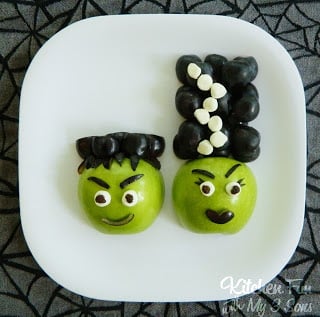 Small apples and fruit snacks decorated to look like Frankenstein and his bride
