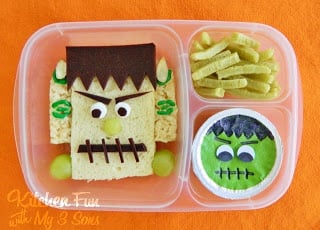 A plastic lunchbox full of food decorated to look like Frankenstein's monster