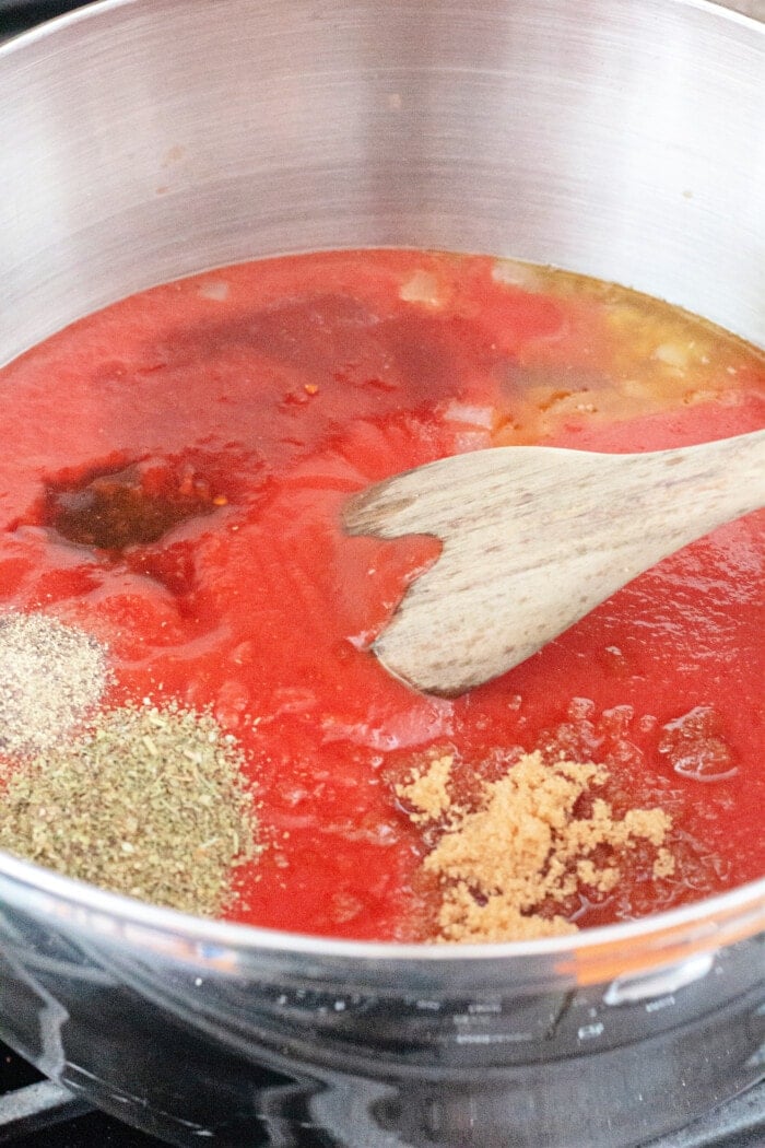 Mixing tomato sauce in a pan