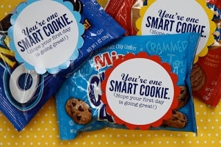 Three bags of mini store-bought cookies with "you're one smart cookie" written on a decorative piece of paper attached to the bags