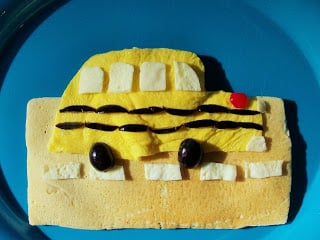 A rectangle pancake with an egg on top decorated to look like a driving school bus