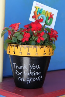 A flower pot with a ruler drawn on the rim and "Thank You for helping me grow" written on it