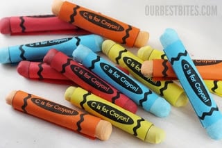 A pile of orange, blue, red and yellow candy crayons on top of a kitchen countertop