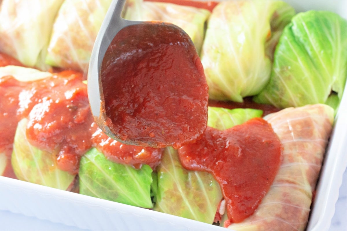 adding sauce over cabbage rolls
