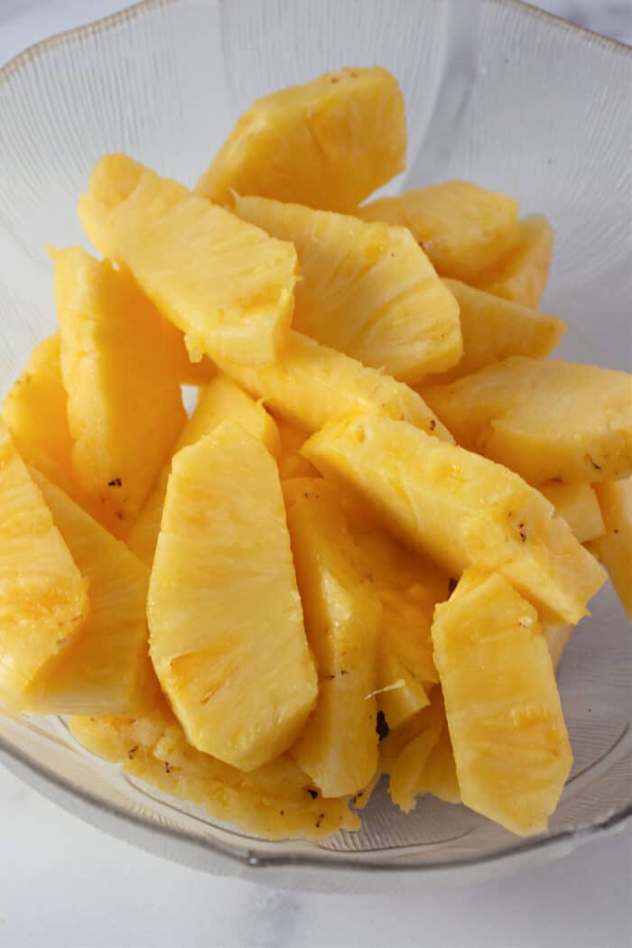 freshly slices of pineapple in a clear bowl.