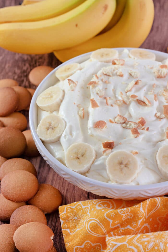 Banana pudding dip on a wood table with a yellow napkin.