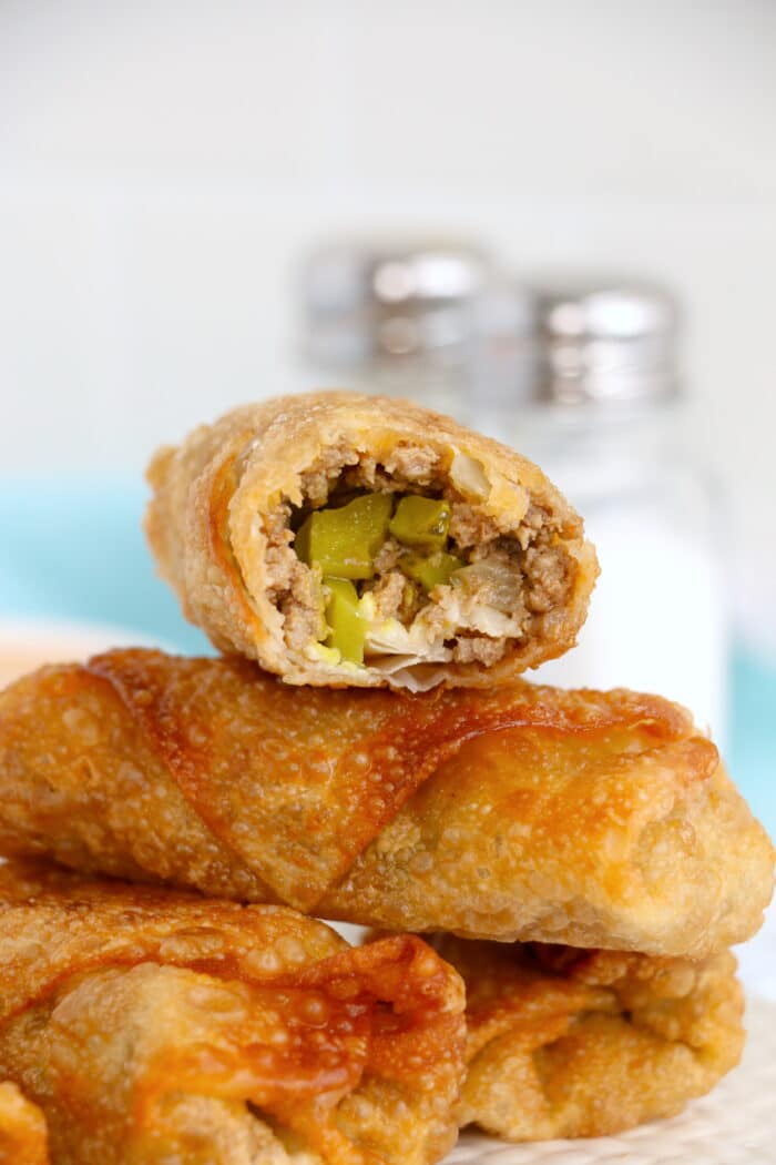Big Mac Egg Rolls with a bite taken out on a pile of egg rolls.