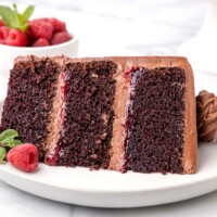 chocolate raspberry cake on a plate with fresh raspberries