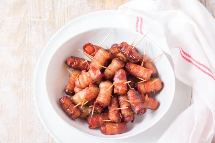 The Crockpot Bacon Wrapped Smokies in a white bowl.