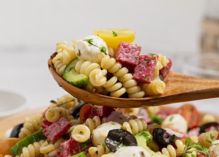 A spoon lifting up some of the Italian Pasta Salad.