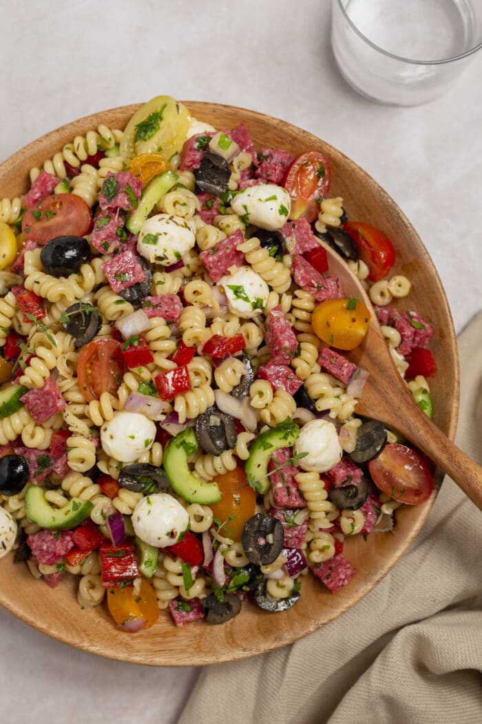A spoon in the bowl of Italian Pasta Salad.