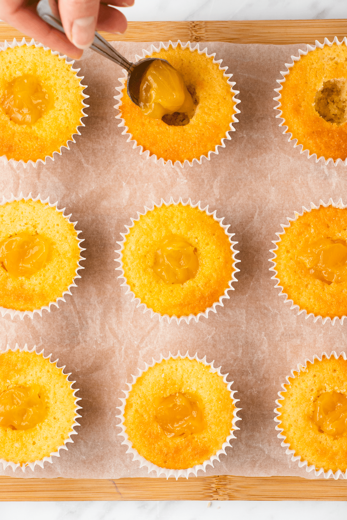 Cupcakes being filled with lemon curd