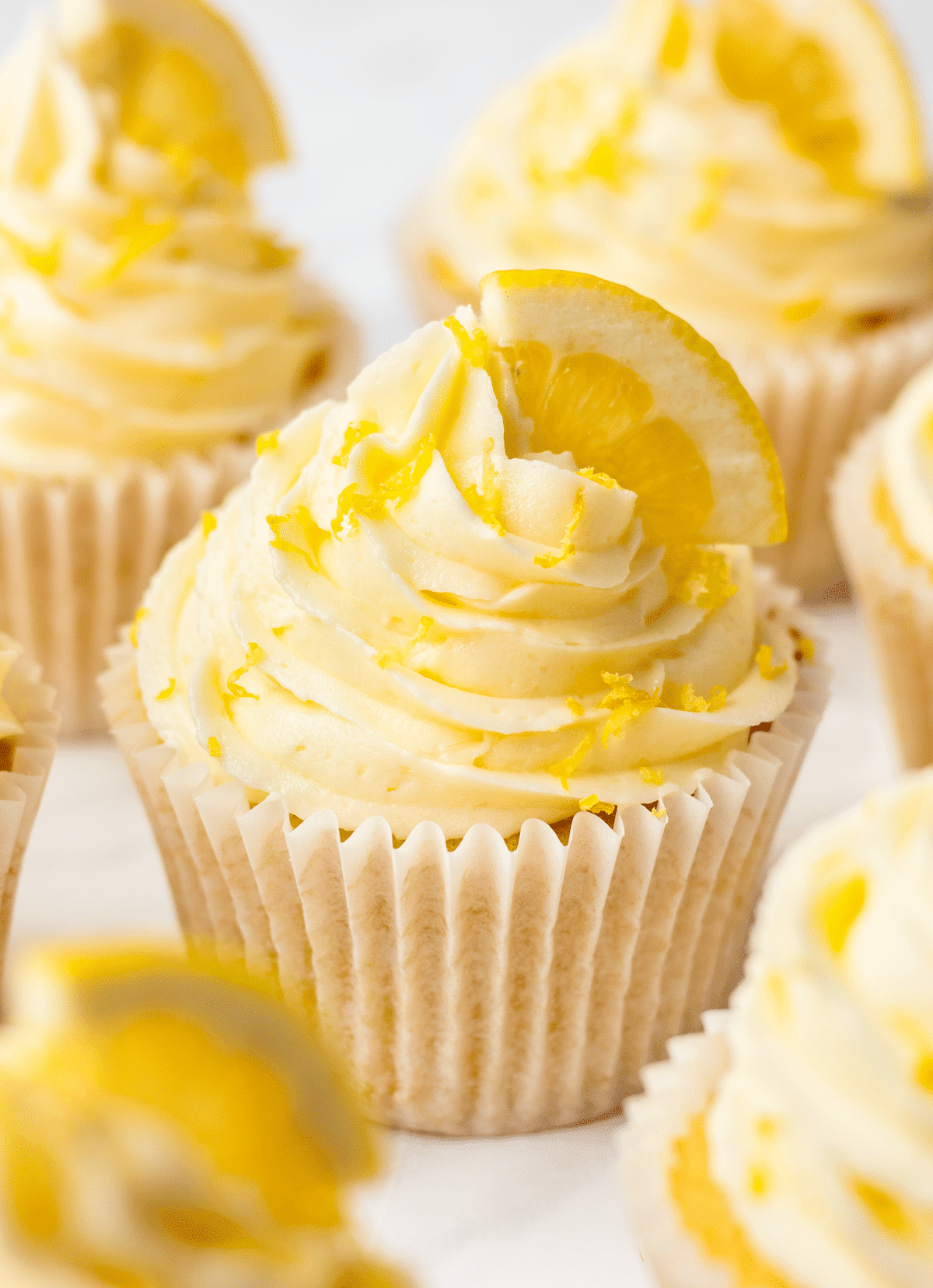 Overhead angled views of lemon cupcakes with lemon buttercream frosting