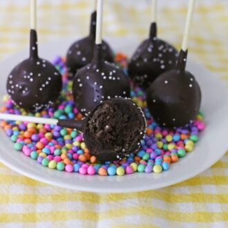 Chocolate Cake Pops on a plate with rainbow sprinkles.