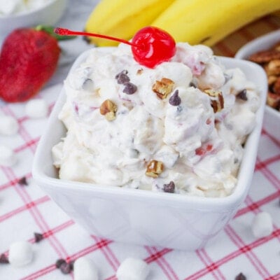 Banana split fluff salad topped with a cherry