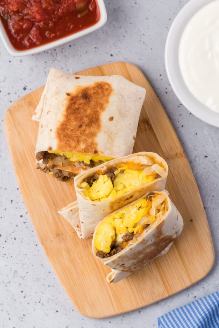 The Breakfast Burritos on a wooden board.