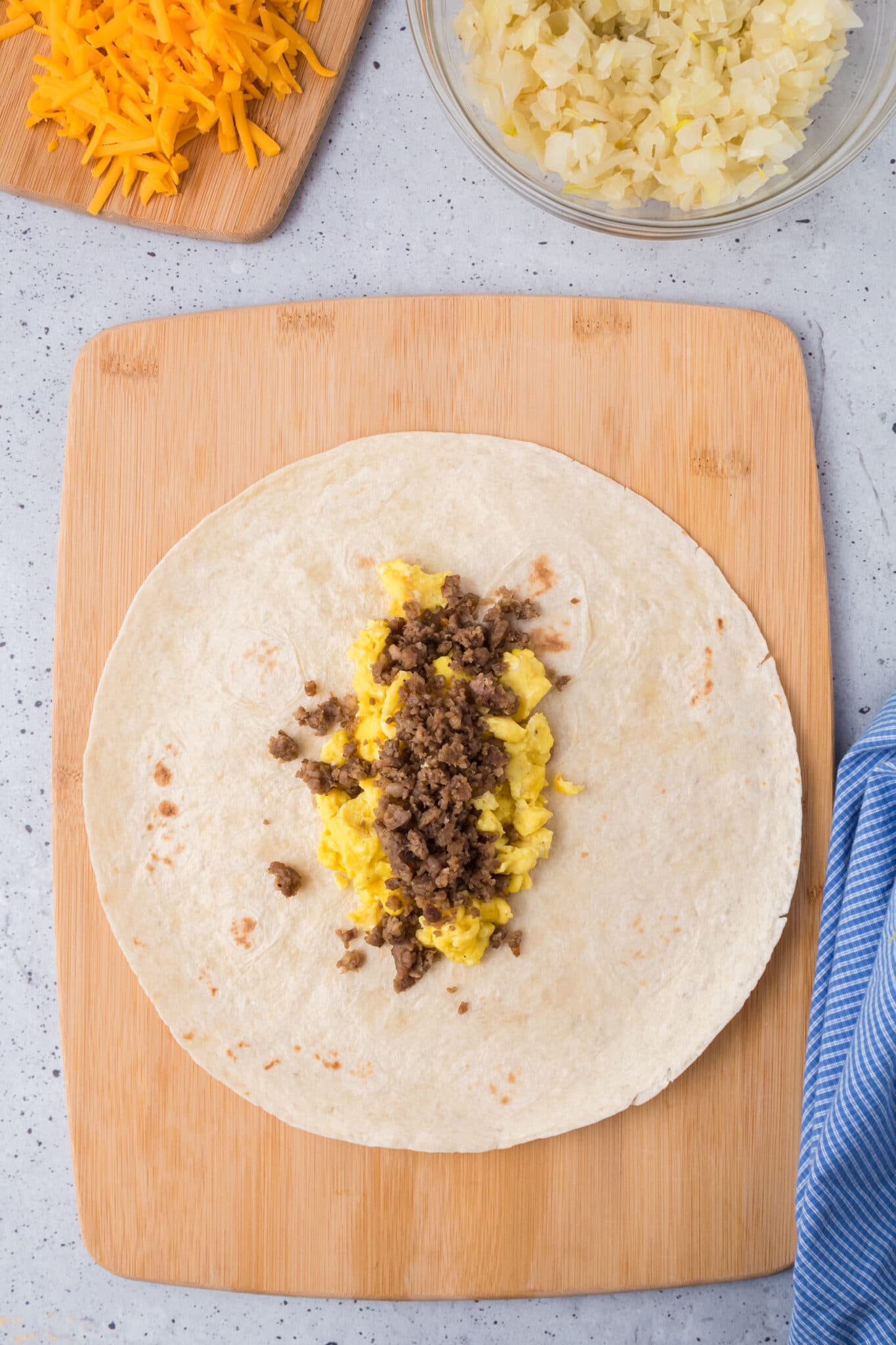 Adding the cooked ingredients to the burrito.